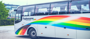 Front of a bus with logo Flygbussarna and multicolored banner. Photo.